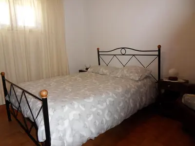 a bedroom with a bed with a white comforter at Moradia Vale da Telha in Aljezur