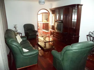 a living room with two green chairs and a tv at Villa Palmeiras in Funchal