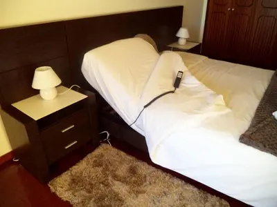 two twin beds in a room with a night stand and a lamp at Villa Palmeiras in Funchal