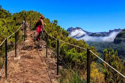 a woman walking on a trail in the mountains at Villa Palmeiras in Funchal