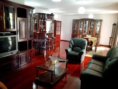 a living room with a tv and chairs and a table at Villa Palmeiras in Funchal