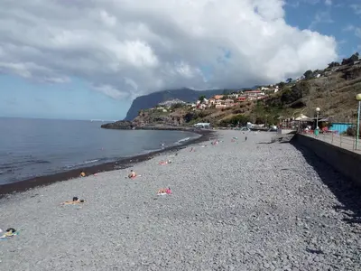 a group of people laying on a rocky beach at Sea Balcony in Funchal