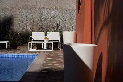 two white chairs sitting next to a swimming pool at Funchal Charming Villa in Funchal