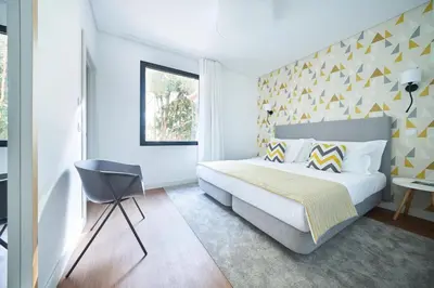 a bedroom with a king sized bed and a chair at Funchal Charming Villa in Funchal