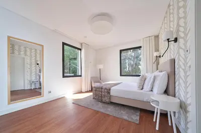 a white bedroom with a bed and a mirror at Funchal Charming Villa in Funchal