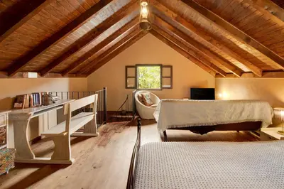 a attic bedroom with a bed and a desk at The Perfect Cottage in São Vicente