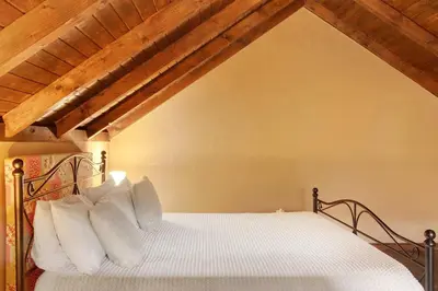 a living room with a couch and a desk with a computer at The Perfect Cottage in São Vicente