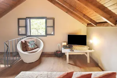 a bed with a pillow and a lamp on a table at The Perfect Cottage in São Vicente