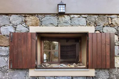 a kitchen with wooden cabinets and a sink and a window at The Perfect Cottage in São Vicente