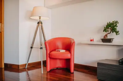 a red chair sitting next to a floor lamp at Funchal Lounge Apartment by Amazing Madeira in Funchal