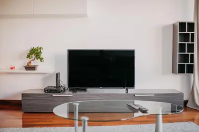 a living room with a tv and a glass coffee table at Funchal Lounge Apartment by Amazing Madeira in Funchal