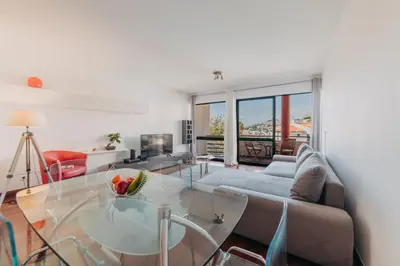 a living room with a glass table and a couch at Funchal Lounge Apartment by Amazing Madeira in Funchal