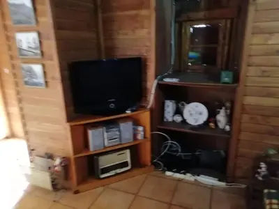 a living room with a flat screen tv and a microwave at Ocean View Cottage in Arco da Calheta
