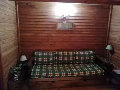 a couch in a room with a wooden wall at Ocean View Cottage in Arco da Calheta