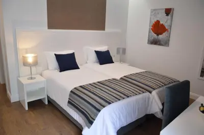 a bedroom with a large white bed with blue pillows at Edificio Charles 103 in Funchal