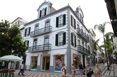 a white building with people walking in front of it at Edificio Charles 206 in Funchal