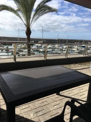 a bench with a view of a marina with boats at Marina Rooms in Calheta