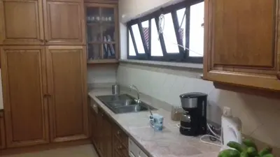 a kitchen with wooden cabinets and a sink and a window at Funchal Bay View Holiday Rental in Funchal