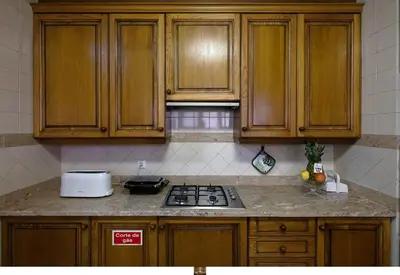 a kitchen with wooden cabinets and a stove top oven at Funchal Bay View Holiday Rental in Funchal