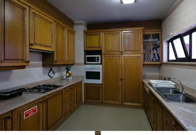 a kitchen with wooden cabinets and a stove top oven at Funchal Bay View Holiday Rental in Funchal