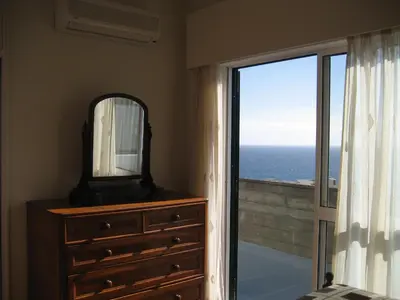 a bedroom with a dresser with a mirror and a window at Yourpenthouseinmadeira in Funchal
