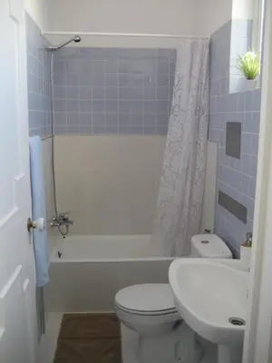 a bathroom with a toilet and a tub and a sink at Yourpenthouseinmadeira in Funchal