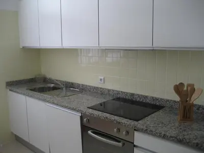 a kitchen counter with a sink and white cabinets at Yourpenthouseinmadeira in Funchal