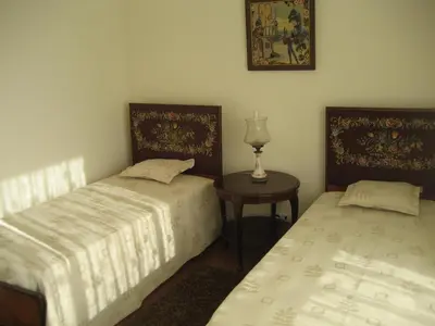 two beds in a room with a table and a lamp at Yourpenthouseinmadeira in Funchal