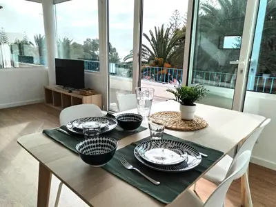 a dining room table with plates and glasses on it at Porto Santo - Pedras Pretas Beach House in Porto Santo