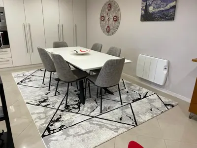 a dining room with a white table and chairs at Casa da Grota in Porto Moniz