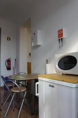 a small kitchen with a table and a microwave at Casa dos Caseiros in Santa Cruz