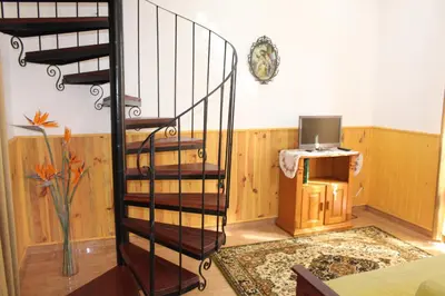 a spiral staircase in a room with a tv at Casa dos Caseiros in Santa Cruz