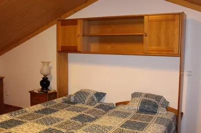 a bedroom with a bed with a cabinet above it at Casa dos Caseiros in Santa Cruz