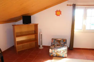a room with a book shelf and a tv on the wall at Casa dos Caseiros in Santa Cruz