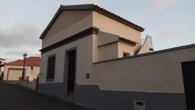 a white building with a door on the side at Casa dos Caseiros in Santa Cruz