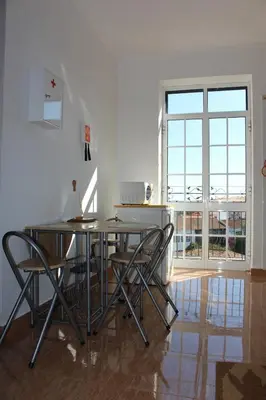 a dining room with a table and chairs and a window at Casa dos Caseiros in Santa Cruz
