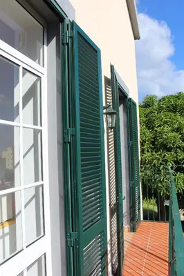 a window with green shutters on a building at Casa dos Caseiros in Santa Cruz