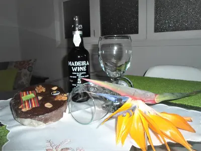 a table with a bottle of wine and a cake at City Apartment in Funchal