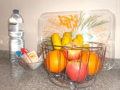 a basket of fruit on a counter next to a bottle of water at City Apartment in Funchal