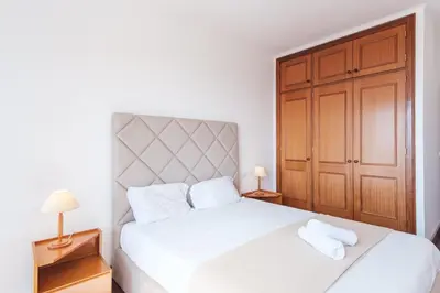 a bedroom with a white bed with two towels at Varandas Funchal-Near center in Funchal