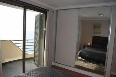 a bedroom with a view of a bed and a balcony at Plaza Bay Luxury Apartment with Swimming Pool in Estreito da Calheta