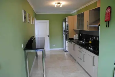 a kitchen with a sink and a dishwasher at Plaza Bay Luxury Apartment with Swimming Pool in Estreito da Calheta