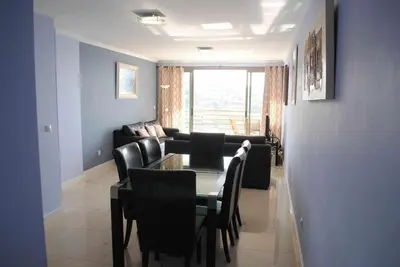 a living room with a table and chairs and a couch at Plaza Bay Luxury Apartment with Swimming Pool in Estreito da Calheta