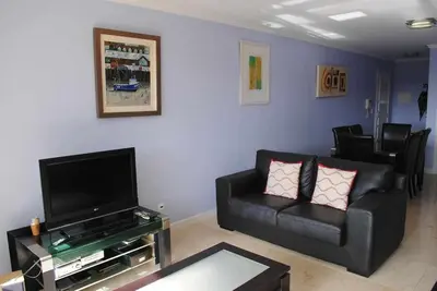 a living room with a couch and a flat screen tv at Plaza Bay Luxury Apartment with Swimming Pool in Estreito da Calheta