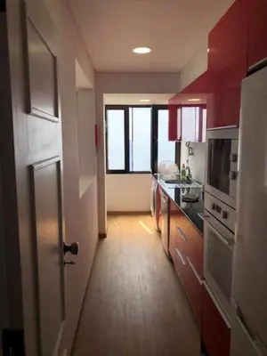 a kitchen with red cabinets and a hallway with a door at Cliff View III - Sea View + Pool + Wifi in Funchal