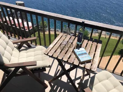 a wooden table and chairs on a balcony at Cliff View III - Sea View + Pool + Wifi in Funchal