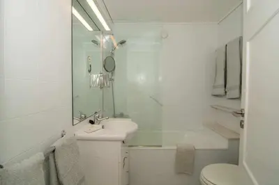 a white bathroom with a sink and a toilet at Cliff View III - Sea View + Pool + Wifi in Funchal