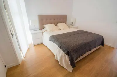 a white bedroom with a large bed with two pillows at Cliff View III - Sea View + Pool + Wifi in Funchal