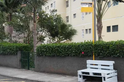 a white bench sitting on a sidewalk next to a building at Inmaculado Apartment in Funchal