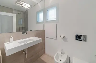 a white bathroom with a sink and a mirror at OurMadeira - Villa Aquarela in Caniço